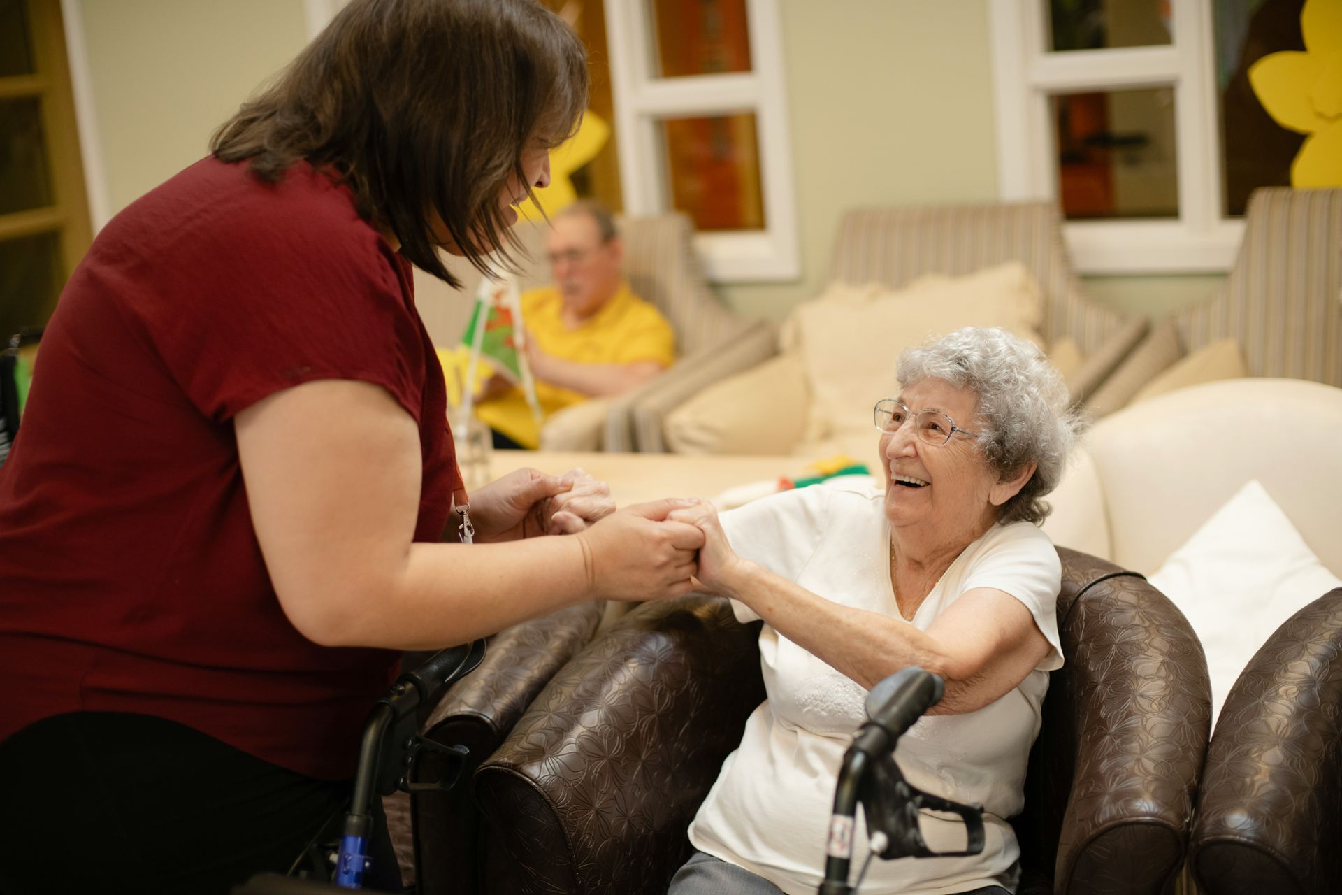 Caregiver assists elderly woman with walker